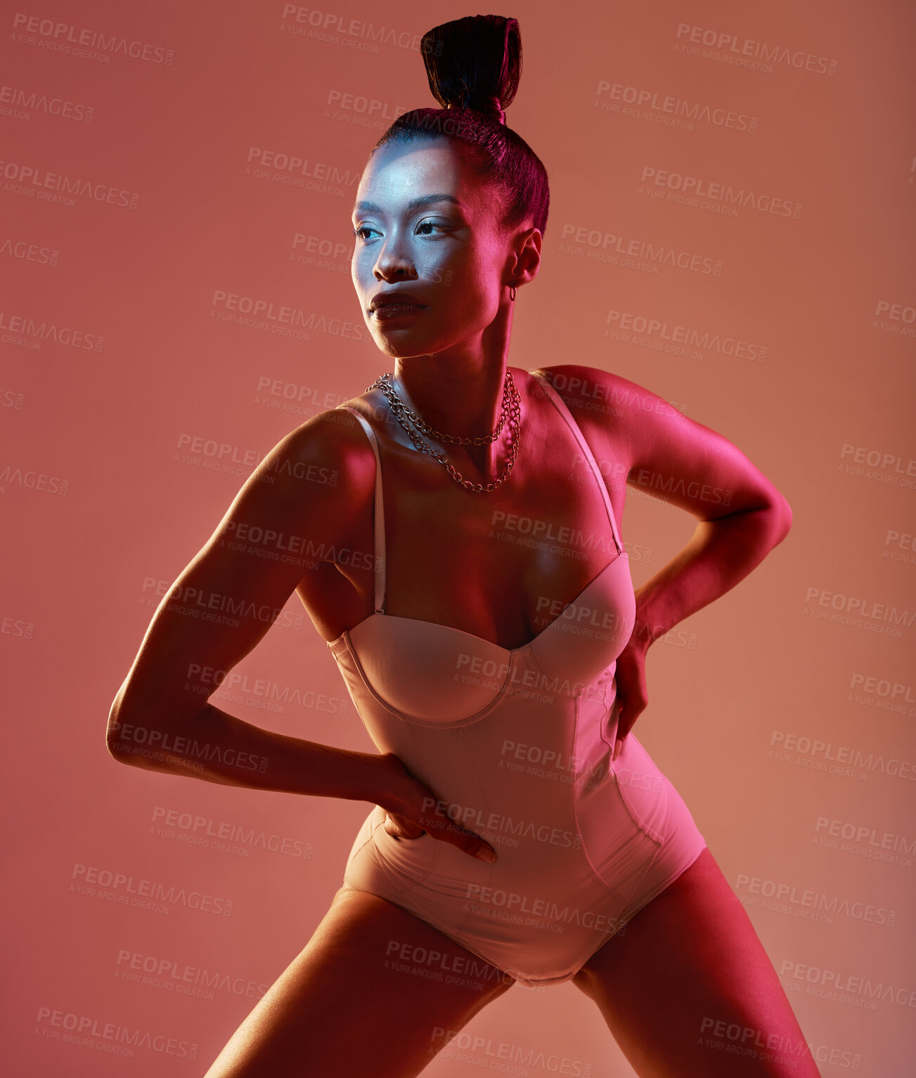 Buy stock photo Art, beauty and neon with a model black woman in studio posing in underwear on an orange background. Aesthetic, creative and fashion with an attractive young female standing on a kaleidoscope wall