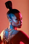 Beauty, jewellery and portrait of a woman in a studio with neon lights for aesthetic and cosmetics. Makeup, art and young female model with a cosmetic routine with jewelry posing by orange background