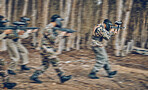 Motion, blur and men running during paintball game, competition and military training in nature. War, field and friends moving with gun for battle, action and cardio in the woods or forest of Mexico