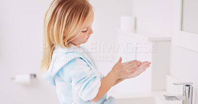 Girl washing her hands in the bathroom of her home for hygiene, stop germs and prevent bacteria. Healthcare, clean and young child doing sanitary routine with soap and water in the basin at her house
