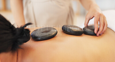 Buy stock photo Hands, masseuse or hot stone massage in spa, salon or healthcare wellness retreat in self care, muscle release or stress management. Women, back or luxury rocks in zen, calm or relax skincare therapy