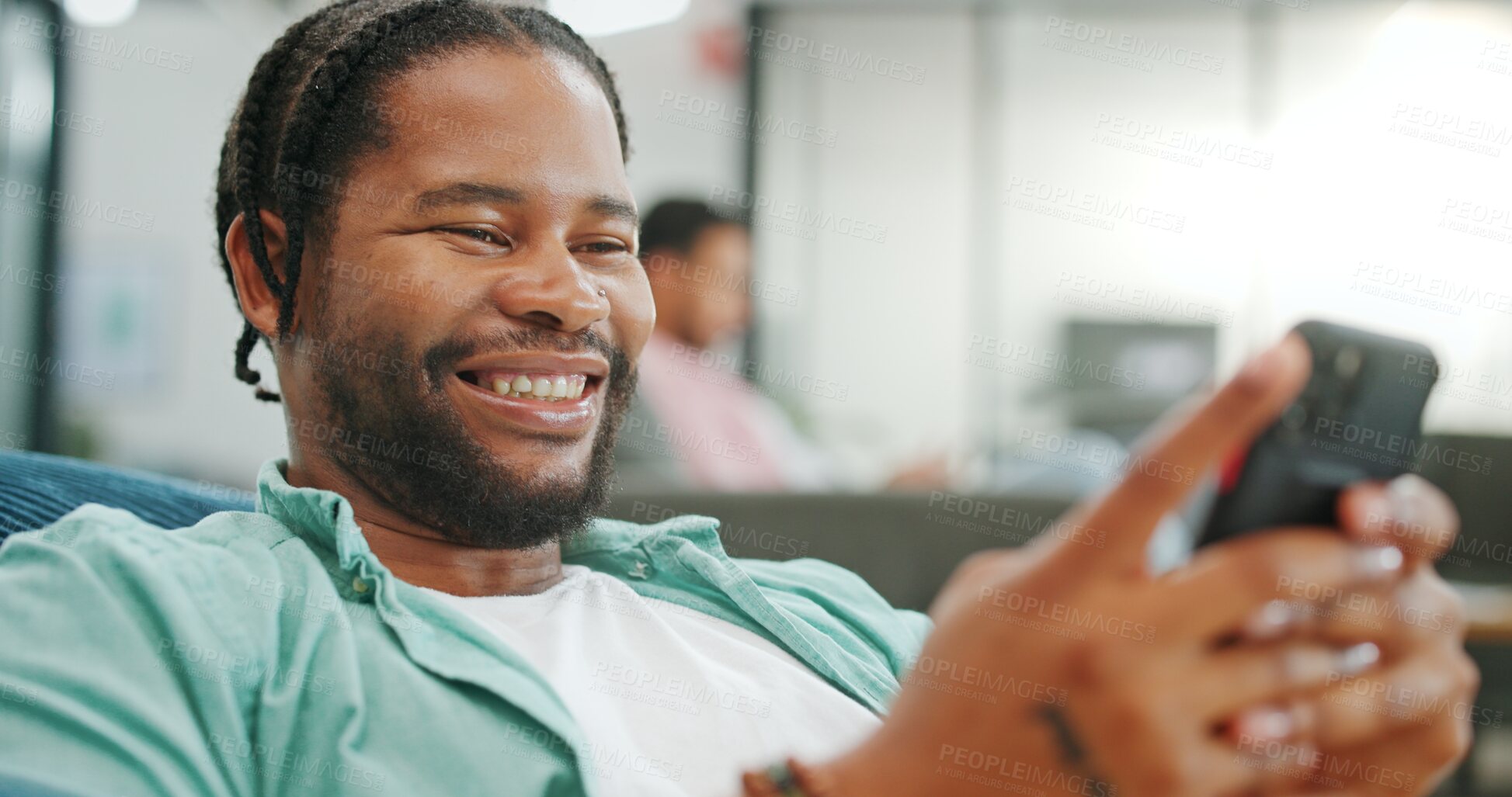 Buy stock photo Black man, phone and office for reading, texting or funny meme with laugh, smile or web chat at startup. African employee, smartphone and contact on social media app, comic video or blog in workplace