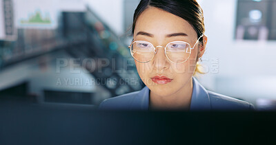 Face, glasses and management with a business asian woman at work on a computer in her office. Data, reading and email with a young female employee working on a report using a desktop for research