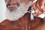 Trimming, beard and face of a man with a scissors isolated on a white background in a studio. Zoom, hygiene and elderly person cutting facial hair, cleaning and grooming for a treatment on a backdrop