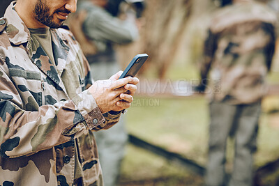 Buy stock photo Chat, typing and man with a phone in the army for communication, social media and contact. Website, email and person reading a message on a mobile app while playing paintball on a field with friends