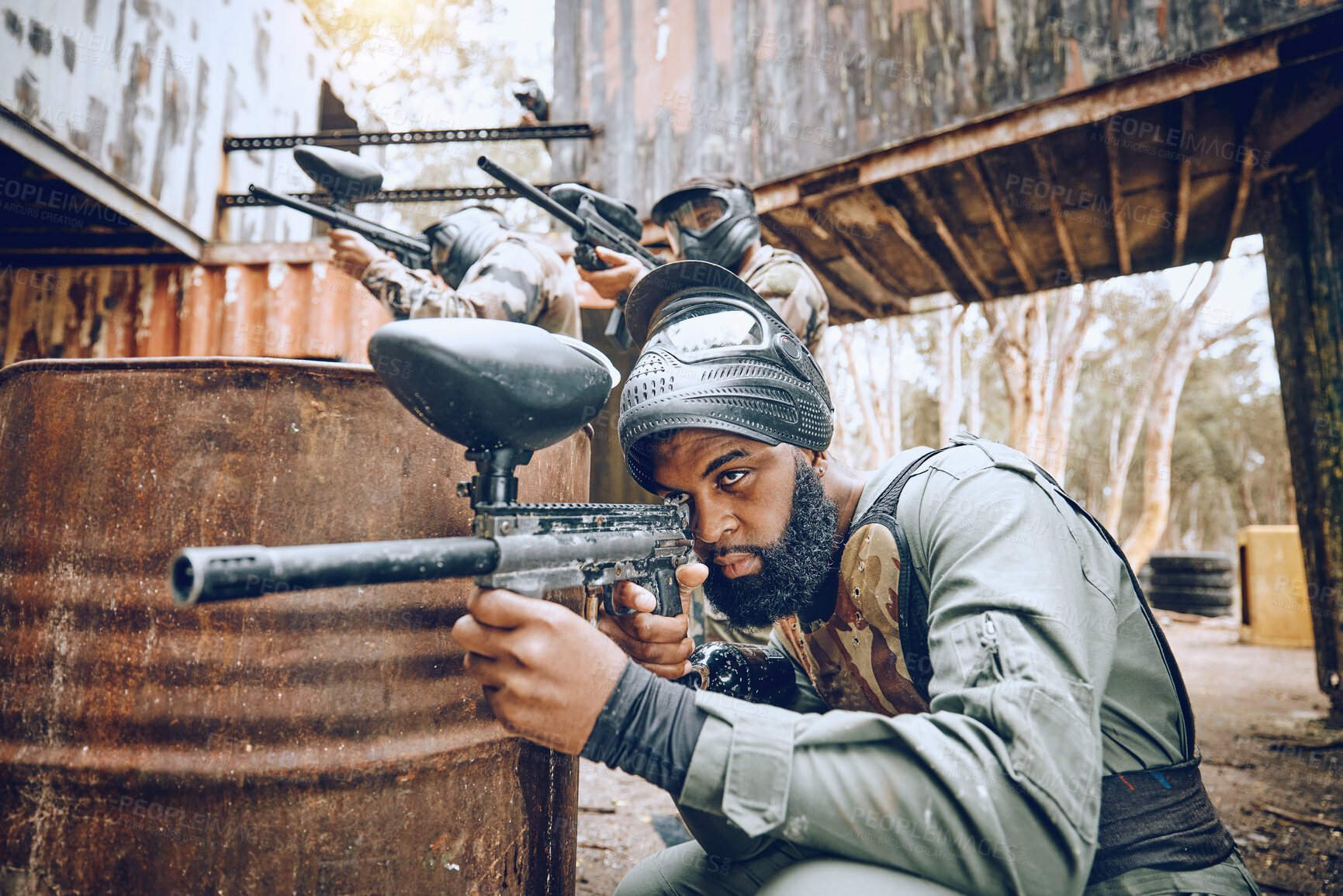 Buy stock photo Paintball, black man and game, gun and target, sport with fitness and battlefield challenge, war and soldier outdoor. Extreme sports, exercise at shooting range and military team with mission