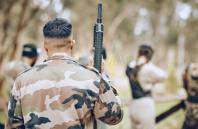 Buy stock photo Paintball, soldier or man with a gun in a shooting game playing on a fun battlefield in nature or forest. Back view, military or warrior with weapons gear for survival in an outdoor competition 