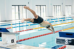 Sports, swimming pool and man diving in water for training, exercise and workout for competition. Fitness, wellness and professional male athlete in action for dive, jump and race from diving board