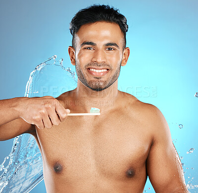 Portrait, water and man with toothbrush, toothpaste and dental hygiene on blue studio background. Male, gentleman and oral health for clean mouth, smile and fresh breath with healthy gums on backdrop