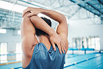 Rear view, man and stretching at swimming pool for training, cardio and exercise, indoor and flexible. Hand, back and swimmer stretch before workout, swim and fitness routine, warm up and preparation