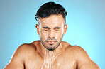 Water, face and facial by man for beauty, skin and skincare and topless wash or shower. Mexican, male and wellness model with moisture, cleanse and hydration isolated in studio blue background
