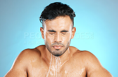 Buy stock photo Water, face and facial by man for beauty, skin and skincare and topless wash or shower. Mexican, male and wellness model with moisture, cleanse and hydration isolated in studio blue background