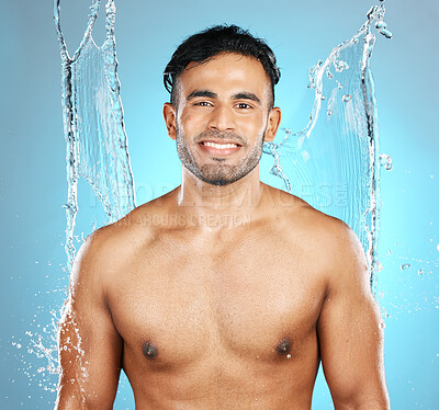 Buy stock photo Water, splash and portrait of man for beauty, skin and skincare cleaning his body, muscle and topless. Mexican, male model with moisture, cleanse and hydration isolated in studio blue background
