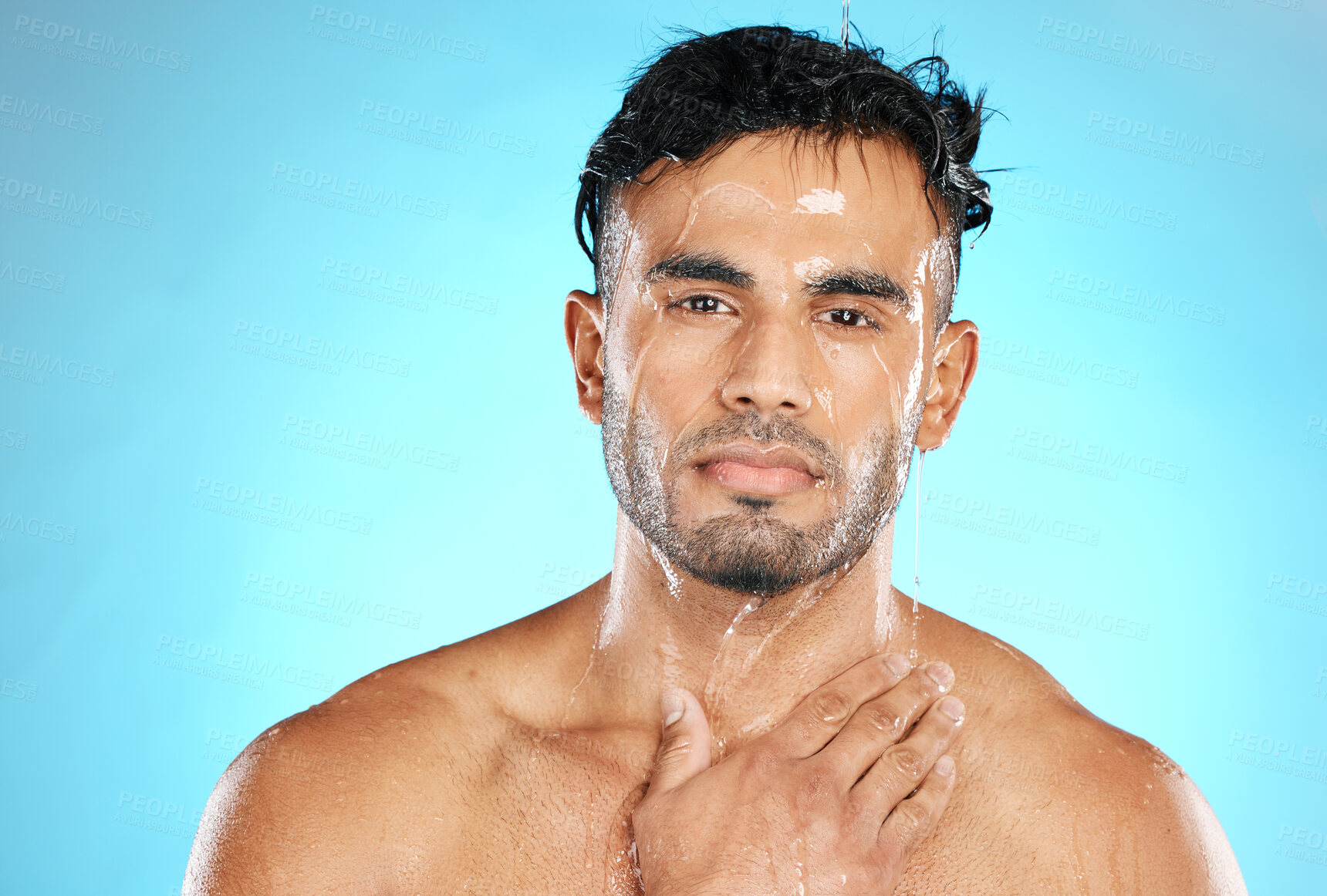 Buy stock photo Skincare, portrait and man in studio for water splash, wellness and grooming on blue background. Face, cleaning and guy model in luxury shower, facial and beauty, skin and  routine while isolated 