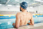 Swimming cap, pool and back of a man preparing for competition, exercise or training in a pool. Sports, fitness and professional male swimmer standing ready for water workout, challenge or sport race