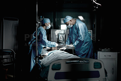 Buy stock photo Surgery, doctors and surgeon in medical theatre for teamwork, expert services or emergency in dark room. Doctors saving patient life on table in hospital theater for healthcare, insurance and support