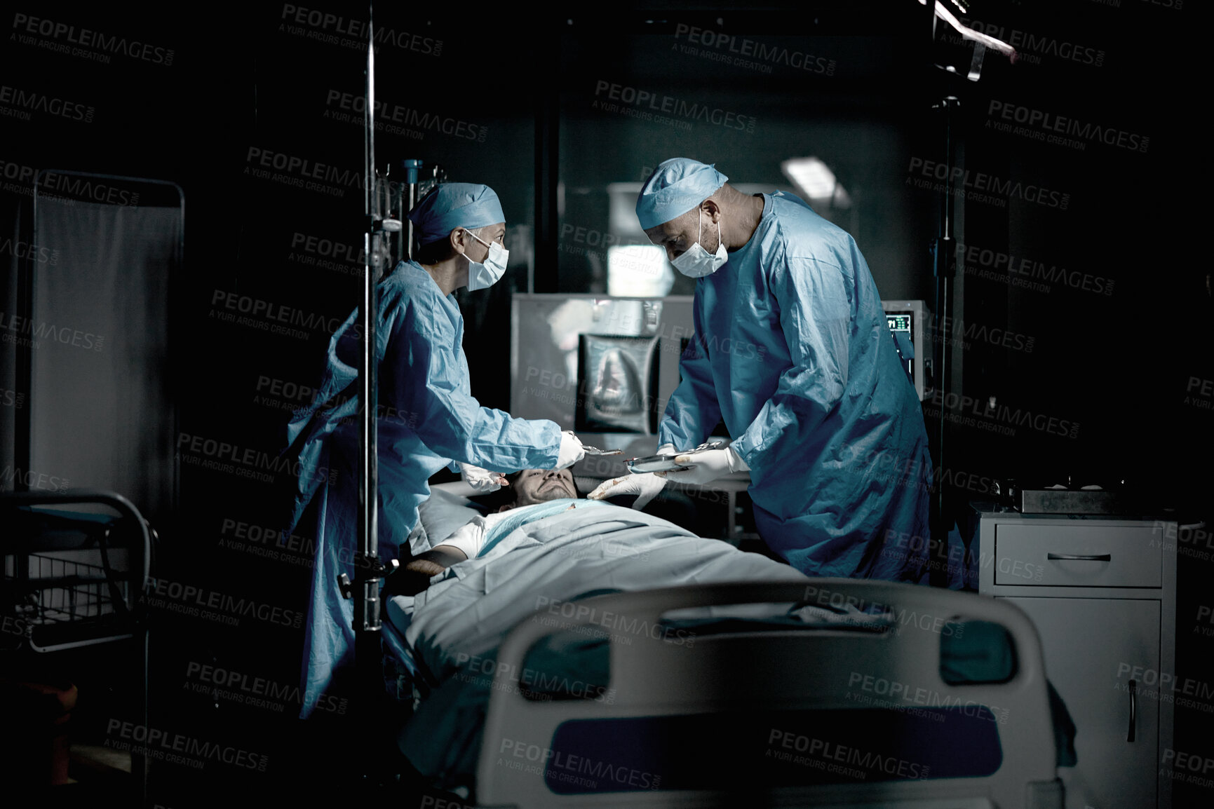 Buy stock photo Surgery, doctors and surgeon in medical theatre for teamwork, expert services or emergency in dark room. Doctors saving patient life on table in hospital theater for healthcare, insurance and support