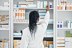 Choice, back and pharmacist at a shelf for medicine, inventory and check on pills in a clinic. Medical, healthcare and black woman working with medication at a phamacy for service, health and work