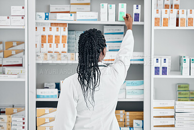 Buy stock photo Choice, back and pharmacist at a shelf for medicine, inventory and check on pills in a clinic. Medical, healthcare and black woman working with medication at a phamacy for service, health and work