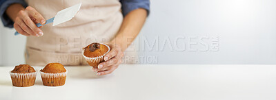 Buy stock photo Chef, cupcakes and person icing muffin with mockup or copy space isolated against a white background. Closeup, hands and cook preparing and decorating dessert or treat on a kitchen table