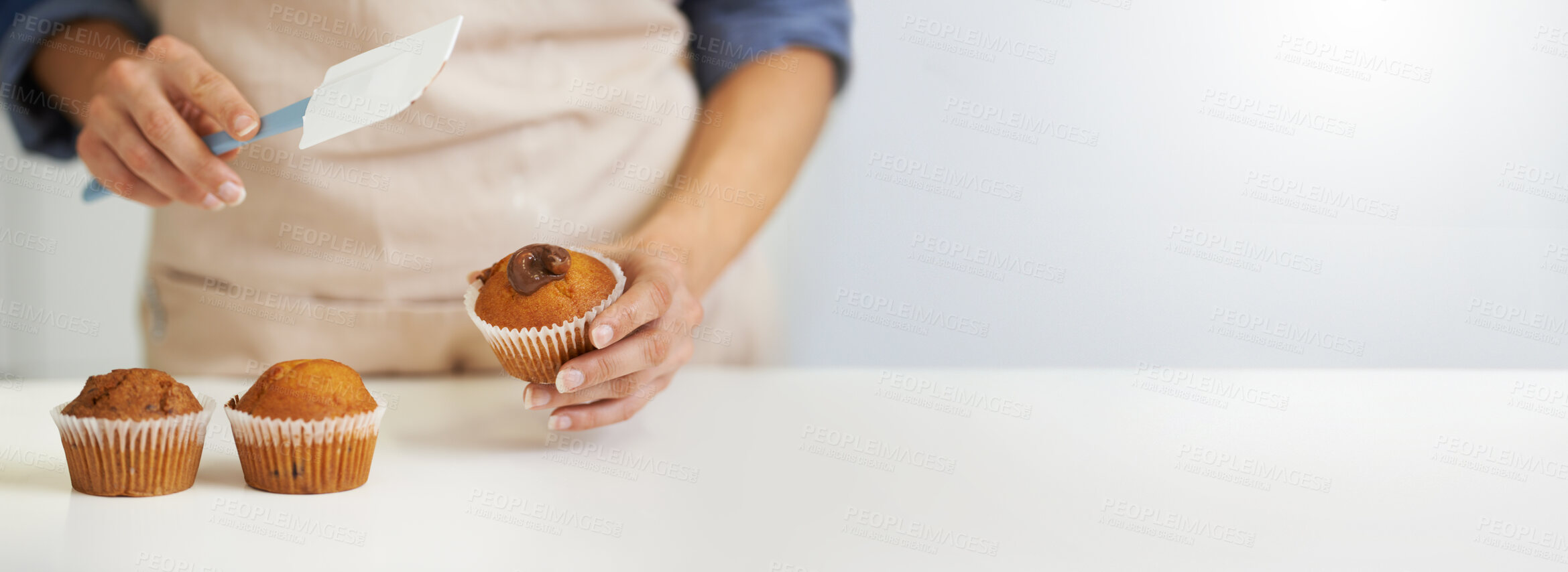 Buy stock photo Chef, cupcakes and person icing muffin with mockup or copy space isolated against a white background. Closeup, hands and cook preparing and decorating dessert or treat on a kitchen table