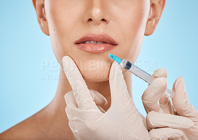 Buy stock photo Closeup, woman and needle on lips for cosmetics, dermatology and treatment for beauty, wellness and against blue studio background. Female, lady and injection for mouth, plastic surgery and skincare