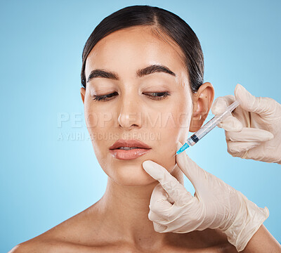 Needle, woman and plastic surgery for skincare, collagen or beauty clinic in studio. Botox cosmetics, face injection and aesthetic filler for body transformation, change and makeup on blue background