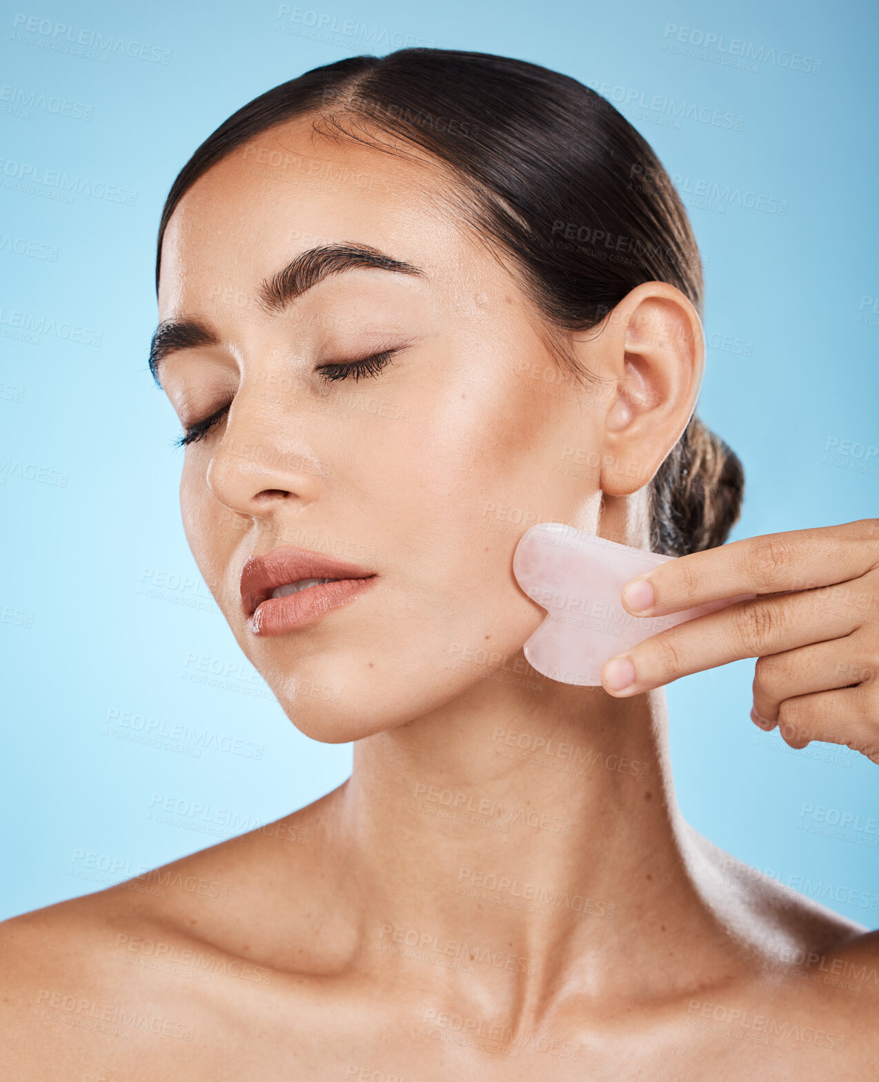 Buy stock photo Face massage, gua sha and skin care woman for dermatology, cosmetics and wellness. Young aesthetic model person for natural stone spa product for facial glow, lines and to relax on blue background