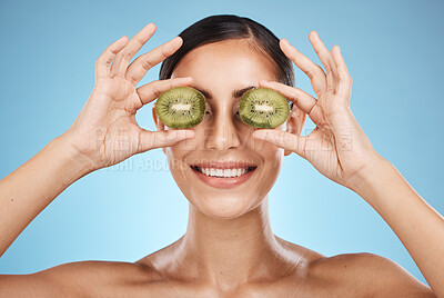 Buy stock photo Beauty, skin care and woman with kiwi fruit face for dermatology, natural cosmetic and wellness. Aesthetic model person for sustainable facial glow, nutrition diet and healthy smile blue background