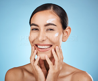 Buy stock photo Face cream, skincare portrait and woman in studio isolated on a blue background. Cosmetics, dermatology and happy female model apply lotion, creme or moisturizer for beauty, aesthetics and wellness.