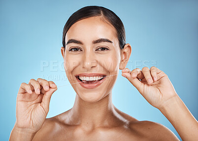 Buy stock photo Woman, flossing in portrait and smile, dental healthcare for fresh breath and clean teeth isolated on blue background. Face, hands and flossing with oral hygiene product and healthy gums in studio