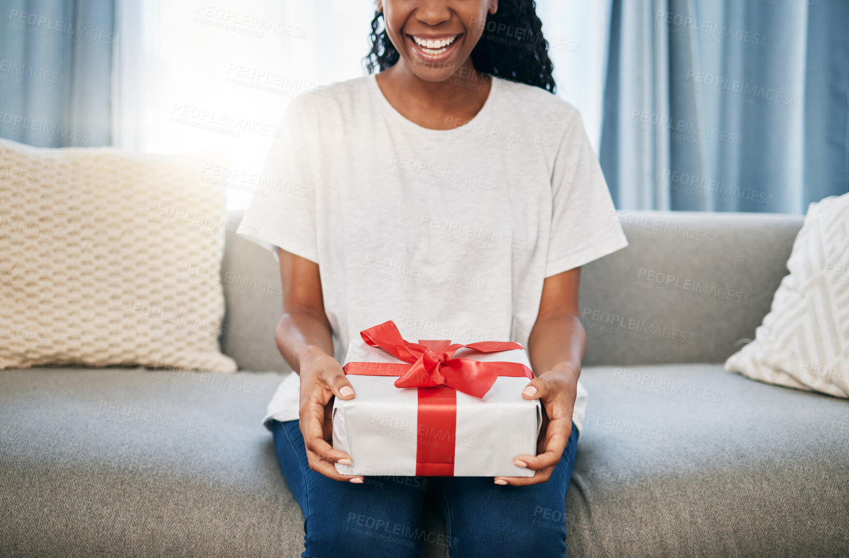 Buy stock photo Present, box and woman on a sofa in the living room with a giving gesture for celebration or event. Bow, wrapping paper and African female with a present for christmas, birthday or holidays in house.