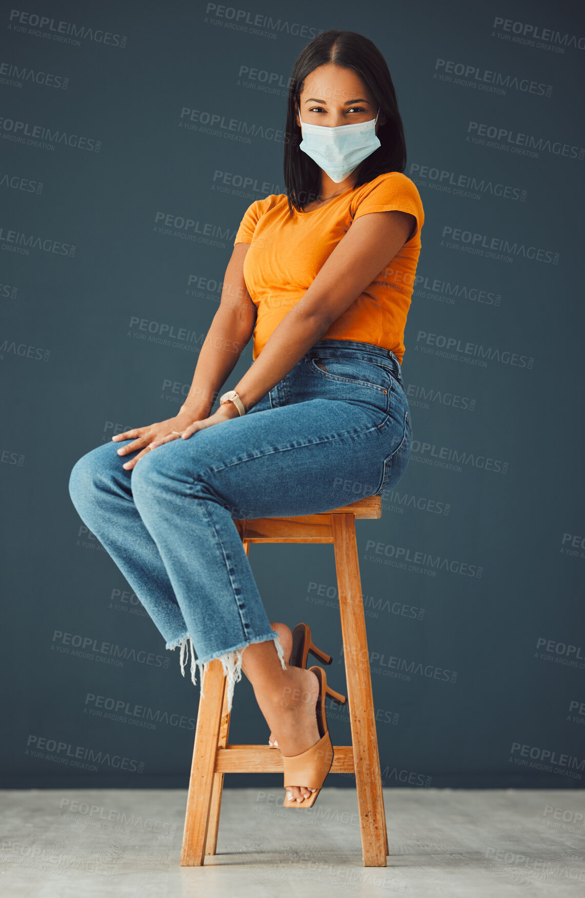 Buy stock photo Covid, model mask portrait and woman sitting on a chair with casual fashion in a studio. Isolated, gray background and young model with marketing space for mockup feeling beautiful and happiness