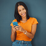 Internet, portrait and phone by woman on social media, mobile or app browsing a website, web or texting. Happy, smiling and female typing online isolated against a studio blue background