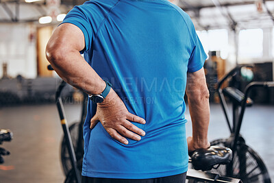 Buy stock photo Sports, gym and old man with hand on back pain, emergency during workout at fitness studio. Health, wellness and inflammation, zoom on senior person hands on muscle cramps while training or exercise.