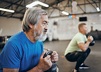 Fitness, senior and man workout with personal trainer at the gym squat with kettlebell equipment for strength. Elderly, old and training people exercise in a health club for wellness and health