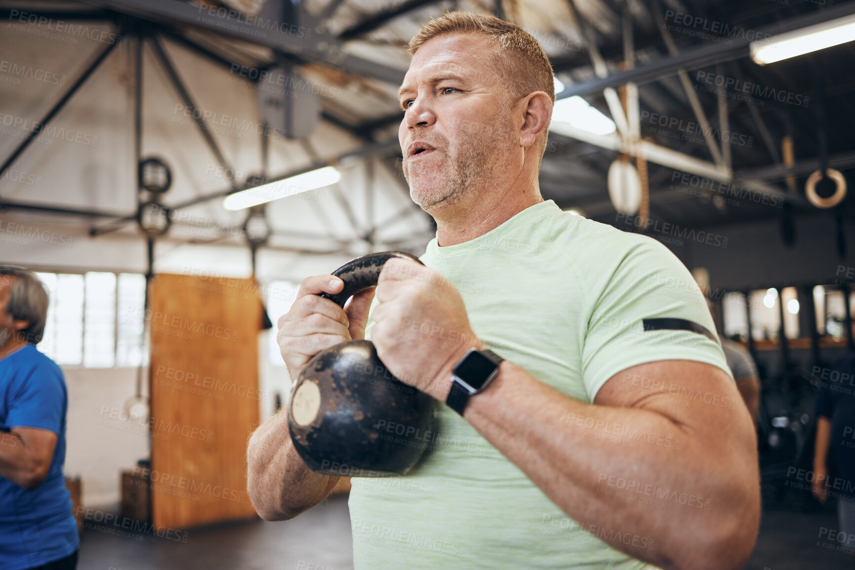 Buy stock photo Elderly man, gym and kettlebell at training for health, wellness and fitness with smartwatch. Senior bodybuilder workout, vision or exercise with group for goal, muscle development or body healthcare