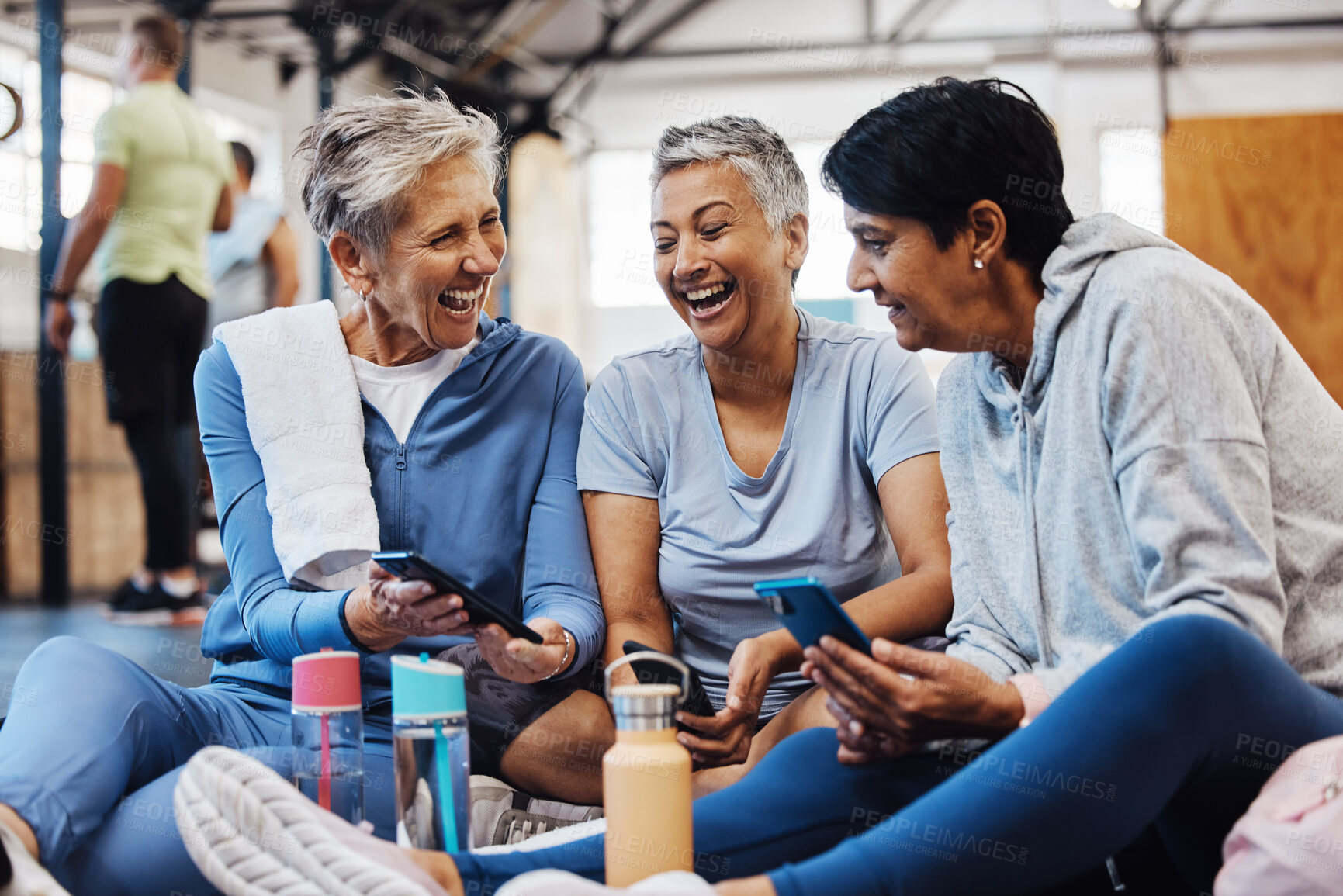 Buy stock photo Gym, smartphone and senior women laughing at meme on phone after fitness class, conversation and comedy on floor. Exercise, bonding and happy mature friends checking social media together at workout.