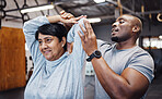Personal trainer, coach and senior woman stretching arms in gym with black man for flexibility. Sports, training and elderly female with male trainer helping with workout and exercise for health.