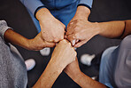 Hands, teamwork and exercise with sports people standing in a huddle at gym from above for health. Collaboration, support and motivation with a man and woman athlete group in a circle for fitness