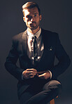 Businessman, suit and portrait in dark studio for corporate fashion, design or professional aesthetic. Young executive leader, model and focus for vision, entrepreneur mindset or tattoo by background