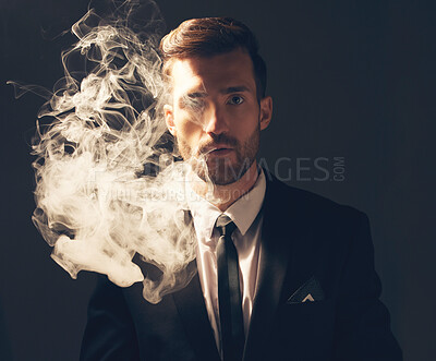 Buy stock photo Executive, portrait and man with smoke in a suit for fashion isolated on a dark background in studio. Sexy, vintage and businessman looking stylish, professional and rich while smoking on a backdrop