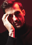 Portrait, fashion and red with a handsome man model in studio on a dark background for contemporary beauty. Face, dramatic or art with a handsome male posing indoor to promote trendy clothes or style