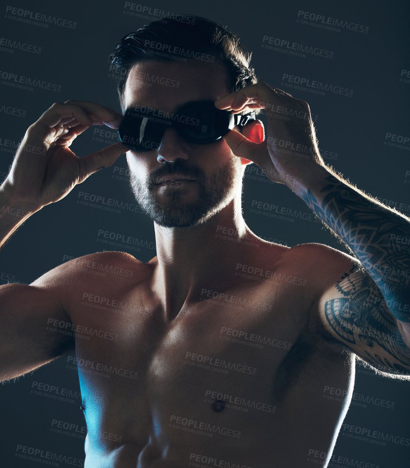 Buy stock photo Fitness, sports and face of swimmer with goggles isolated in studio for wellness, exercise and training. Workout, swimming athlete and man focus on dark background with muscle, strong body and tattoo