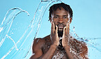 Water splash, facial skincare and portrait of black man with hands on face, morning cleaning isolated on blue background. Hygiene, male model and grooming for health, wellness and skin care in studio