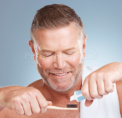 Buy stock photo Hands, toothpaste or old man brushing teeth with dental products in a healthy oral hygiene grooming in studio. Eco friendly, happy or senior man cleaning mouth with a natural bamboo wood toothbrush 