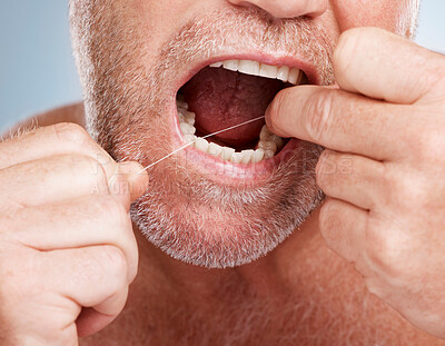 Hands, dental and mouth of man with floss in studio isolated on a gray background for health. Oral hygiene, wellness and senior male model with thread or string for flossing, cleaning or teeth care.