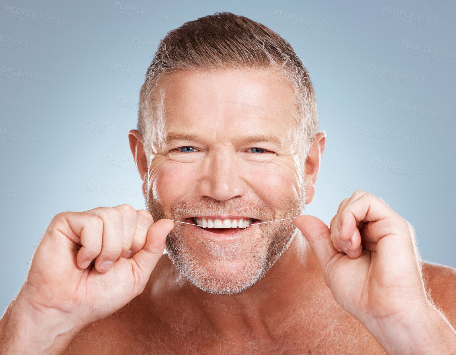 Buy stock photo Floss, portrait and man with dental health for fresh breath, hygiene and cleaning teeth against blue studio background. Oral health, male and string for mouth, morning routine or grooming on backdrop