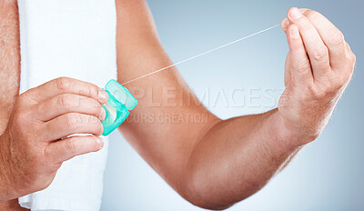 Buy stock photo Hands, dental and floss product in studio isolated on a blue background for oral hygiene. Health, wellness and senior man model holding container with thread for flossing, cleaning and teeth care.