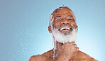 Water, splash and mockup with black man and shower for skincare, hygiene and dermatology. Wellness, spa and facial with senior model cleaning in blue background studio for health, luxury or hydration